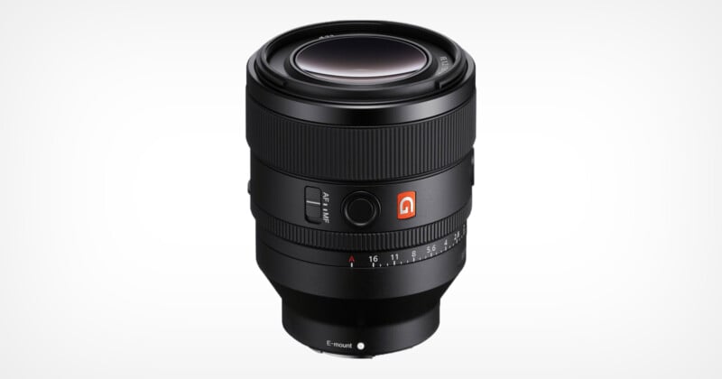 Black camera lens with wide aperture ring, focus switch and branded logo. The lens has clear markings for aperture settings and is designed for E-mount cameras. Lens cap not attached.
