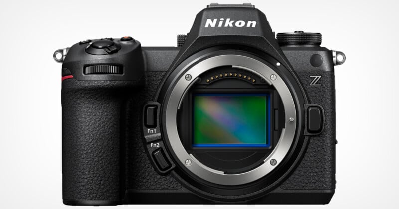 The Nikon Z-series mirrorless camera faces forward, showing its lens mount and sensor. The camera is black with textured grips, visible buttons and a prominent viewfinder housing on top.