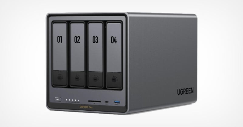 A UGREEN external storage device with four drive bays, each numbered 01 to 04. The front panel houses the indicator lights, power button, and USB and SD card slots. The device is sleek and gray in color with the UGREEN logo on the side.