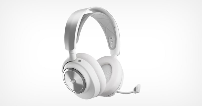 A sleek pair of white over-ear headphones with a built-in microphone. The design features a metal headband and circular ear cups with metallic accents, creating a modern and minimalist look. The microphone is attached to the left ear cup.
