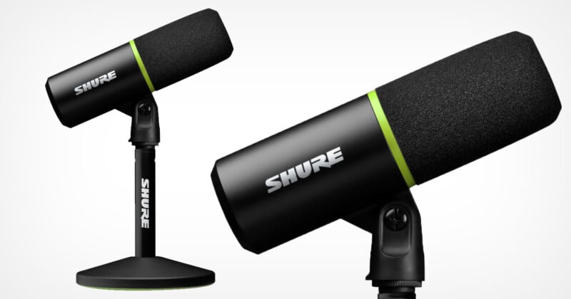 Mounted on a black Shure microphone stand with green accents. Another view of the same microphone is projected upwards in the background. The microphones have a sleek, modern design.